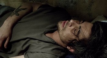 Movie still from “21 Grams” (2003), directed by Alejandro G. Iñárritu – A man laying on the ground with his eyes closed; Close Up shot, Overhead angle