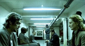 Movie still from “21 Grams” (2003), directed by Alejandro G. Iñárritu – A group of men sitting on a bench in a room; Wide shot, High angle