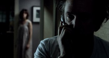 Movie still from “21 Grams” (2003), directed by Alejandro G. Iñárritu – A man on a cell phone in a dark room; Close Up shot, Over the shoulder angle