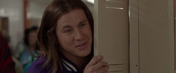 Movie still from “21 Jump Street” (2012), directed by Phil Lord – A man with long brown hair leaning against a wall; Close Up shot, Over the shoulder angle