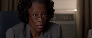 Movie still from “21 Jump Street” (2012), directed by Phil Lord – An older woman wearing glasses and a suit; Close Up shot, Over the shoulder angle