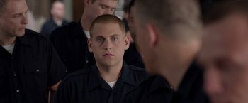 A man in a police uniform looking into a mirror