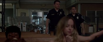 Movie still from “21 Jump Street” (2012), directed by Phil Lord – A police officer standing in front of a woman in a church; Medium shot, Over the shoulder angle