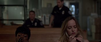 Movie still from “21 Jump Street” (2012), directed by Phil Lord – A woman talking on the phone in front of two police officers; Close Up shot, Over the shoulder angle