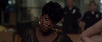 Movie still from “21 Jump Street” (2012), directed by Phil Lord – A woman with short black hair wearing large hoop earrings; Close Up shot, Over the shoulder angle