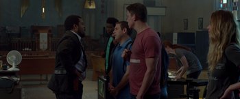 Movie still from “21 Jump Street” (2012), directed by Phil Lord – A group of men standing in front of each other in a room; Medium shot, Over the shoulder angle