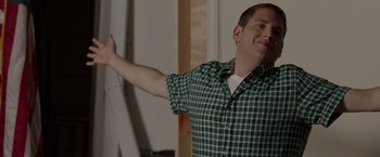 Movie still from “21 Jump Street” (2012), directed by Phil Lord – A man in a green and white plaid shirt raising his hand; Medium shot, Low angle