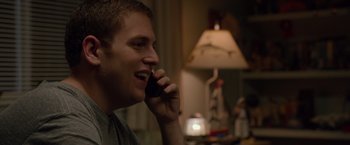 Movie still from “21 Jump Street” (2012), directed by Phil Lord – A man talking on a cell phone while sitting in front of a lamp; Close Up shot, Over the shoulder angle
