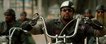 Movie still from “21 Jump Street” (2012), directed by Phil Lord – A man riding a motorcycle on the street wearing a helmet; Close Up shot, Low angle