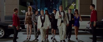 Movie still from “21 Jump Street” (2012), directed by Phil Lord – A group of people in tuxedos walking down a street; Wide shot, Low angle