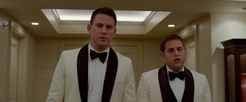 Movie still from “21 Jump Street” (2012), directed by Phil Lord – Two young men in tuxedos standing next to each other; Medium shot, Low angle