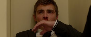 Movie still from “21 Jump Street” (2012), directed by Phil Lord – A man in a suit and tie is holding his hand up to his face; Close Up shot, Overhead angle