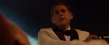 Movie still from “21 Jump Street” (2012), directed by Phil Lord – A man in a white suit and a black bow tie; Close Up shot, Over the shoulder angle