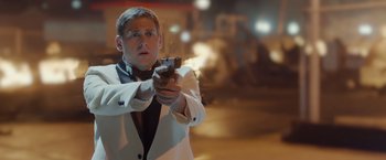 Movie still from “21 Jump Street” (2012), directed by Phil Lord – A man in a white suit is holding a gun; Close Up shot, Over the shoulder angle