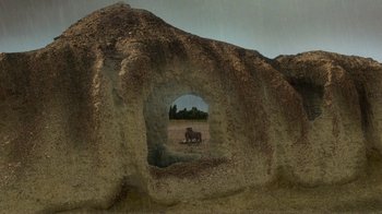 Movie still from “24 Frames” (2017), directed by Abbas Kiarostami – An elephant is standing in a cave looking out at the ground; Extreme Wide shot, Low angle