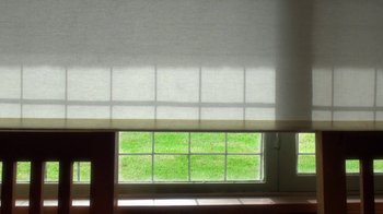 Movie still from “24 Frames” (2017), directed by Abbas Kiarostami – A room with a large window and a green lawn outside it; Extreme Close Up shot, High angle