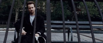 Movie still from “25th Hour” (2002), directed by Spike Lee – A man sitting on top of a wooden park bench; Close Up shot, Low angle