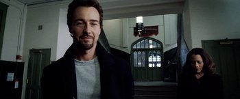 Movie still from “25th Hour” (2002), directed by Spike Lee – A person wearing a jacket near a building; Close Up shot, Low angle