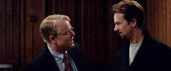 Movie still from “25th Hour” (2002), directed by Spike Lee – Two men in business suits talking to each other; Close Up shot, Over the shoulder angle