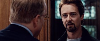 Movie still from “25th Hour” (2002), directed by Spike Lee – A man with glasses and a beard talking to another man; Close Up shot, Over the shoulder angle