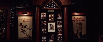 Movie still from “25th Hour” (2002), directed by Spike Lee – Many photos of people in uniform on the wall; Close Up shot, Overhead angle
