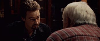 Movie still from “25th Hour” (2002), directed by Spike Lee – A man talking to another man at a table; Close Up shot, Over the shoulder angle