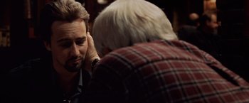 Movie still from “25th Hour” (2002), directed by Spike Lee – A man sitting next to another man in a red and white checkered shirt; Close Up shot, Over the shoulder angle