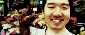 Movie still from “25th Hour” (2002), directed by Spike Lee – A man's smile at a farmers market; Extreme Close Up shot, Low angle