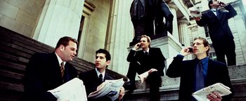 Movie still from “25th Hour” (2002), directed by Spike Lee – A group of men sitting on the steps of a building; Medium shot, Low angle