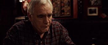 Movie still from “25th Hour” (2002), directed by Spike Lee – An older man in a red and white shirt; Close Up shot, High angle