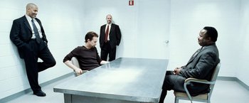 Movie still from “25th Hour” (2002), directed by Spike Lee – A group of men sitting around a table; Medium shot, Over the shoulder angle