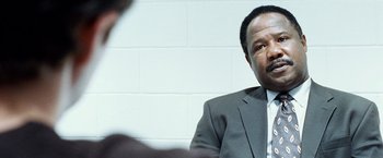 Movie still from “25th Hour” (2002), directed by Spike Lee – A man in a gray suit and a white tie; Close Up shot, Over the shoulder angle