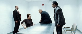 Movie still from “25th Hour” (2002), directed by Spike Lee – A group of men sitting around a table talking to each other; Medium shot, Over the shoulder angle