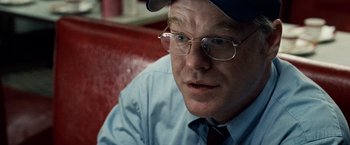 Movie still from “25th Hour” (2002), directed by Spike Lee – A person wearing glasses and a hat; Close Up shot, Over the shoulder angle