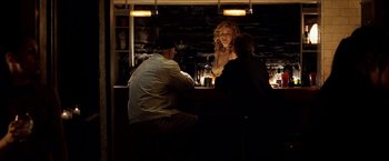 Movie still from “25th Hour” (2002), directed by Spike Lee – A group of people sitting at a bar at night; Medium shot, Over the shoulder angle