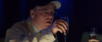 Movie still from “25th Hour” (2002), directed by Spike Lee – A man holding a wine glass in his right hand; Close Up shot, Over the shoulder angle