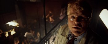 Movie still from “25th Hour” (2002), directed by Spike Lee – A man with glasses is standing in front of a staircase; Close Up shot, Low angle