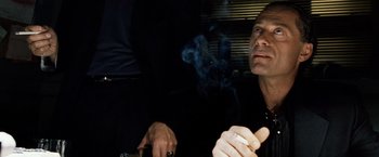 Movie still from “25th Hour” (2002), directed by Spike Lee – A man smoking a cigarette while sitting in a chair; Close Up shot, Low angle