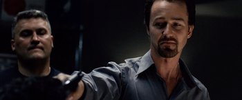 Movie still from “25th Hour” (2002), directed by Spike Lee – A man holding a remote control in his hand; Close Up shot, Low angle