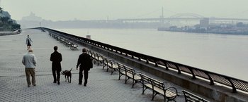 Movie still from “25th Hour” (2002), directed by Spike Lee – A man walking down a sidewalk next to a river; Extreme Wide shot, High angle
