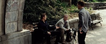 Movie still from “25th Hour” (2002), directed by Spike Lee – Two men sitting on a park bench with a dog; Wide shot, Over the shoulder angle