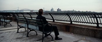 Movie still from “25th Hour” (2002), directed by Spike Lee – A man sitting on a bench looking out over the water; Wide shot, High angle