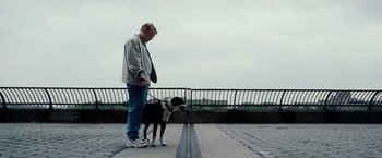Movie still from “25th Hour” (2002), directed by Spike Lee – A man and a dog are standing on a sidewalk; Wide shot, High angle