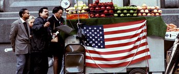 Movie still from “25th Hour” (2002), directed by Spike Lee – A woman standing in front of an american flag; Wide shot, Low angle