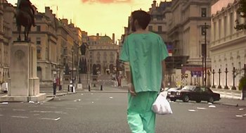 Movie still from “28 Days Later” (2002), directed by Danny Boyle – A man in green scrubs is walking down the street; Wide shot, Low angle