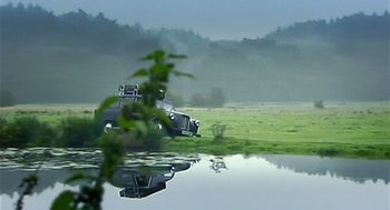 Movie still from “28 Days Later” (2002), directed by Danny Boyle – A truck is parked in the middle of a field; Extreme Wide shot, Low angle