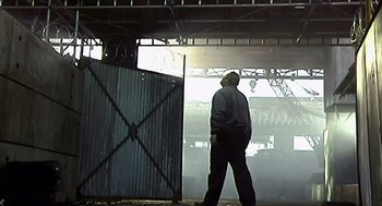 Movie still from “28 Days Later” (2002), directed by Danny Boyle – A man walking in the fog under a bridge; Wide shot, Low angle
