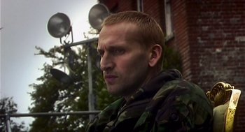 Movie still from “28 Days Later” (2002), directed by Danny Boyle – A person wearing a camouflage jacket; Close Up shot, Low angle