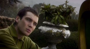 Movie still from “28 Days Later” (2002), directed by Danny Boyle – A young man is standing next to an urn in a garden; Close Up shot, Low angle
