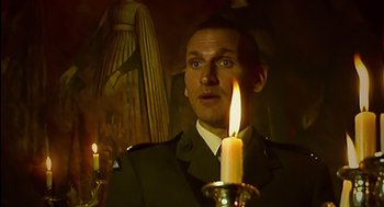 Movie still from “28 Days Later” (2002), directed by Danny Boyle – A man in a military uniform holding a lit candle; Close Up shot, Low angle